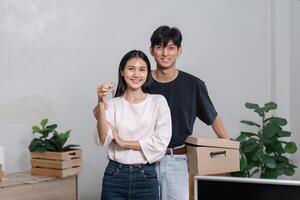 Happy Couple Moving into New Home Holding Keys and Cardboard Box, Smiling and Excited About New Beginnings photo