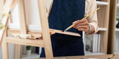 Artist Painting in Studio with Brush and Palette, Close Up of Hands and Canvas, Creative Process in Art Workshop photo