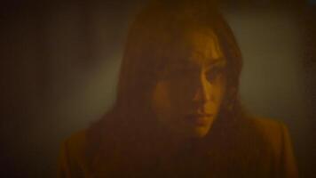 Moody portrait of a woman captured in low light, displaying an intense expression video