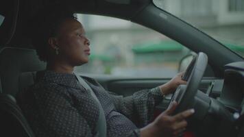 With focus and confidence, a woman drives through the city in an urban environment video