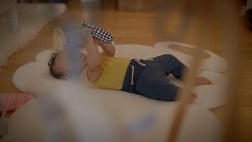 ein Baby ist glücklich spielen mit bunt Spielzeuge auf ein Sanft Wolke Matte im ein gemütlich Zuhause video