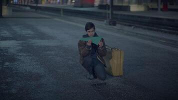Alone explorer examining a map while standing on an empty road in the darkness of night video
