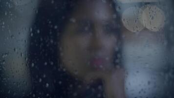 In the city, a woman is obscured by a rainy window, immersed in profound reflection video