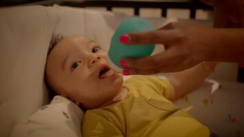 A baby being fed with a silicone bottle while in a crib, facilitating bonding and calming the child video