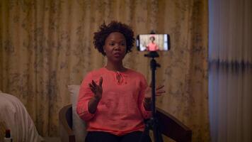A woman records a at home using a smartphone on a tripod in a cozy and modern setting video