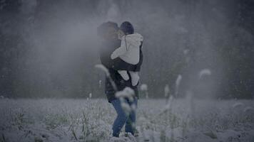 Parent hugging child in snowy landscape, expressing love and making memories in the winter setting video