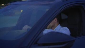 A man is deeply contemplative while seated in his car during the enchanting dusk hours video