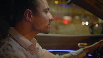 A man is driving at night, surrounded by urban lights that create a stunning background video