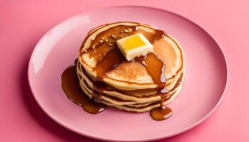 Stack of homemade pancakes with butter and maple syrup on a pink plate, view from above. Top view, overhead, flat lay. Close-up. photo
