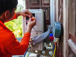 Air conditioning technicians install new compressor air Use a screwdriver to install the air conditioning system wiring and using monitor tool to check air conditioner system. photo