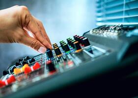 Close-up of sound engineer hands adjusting control sound mixer in recording, broadcasting studio,Sound mixer. Professional audio mixing console, buttons, faders and sliders. sound check. photo
