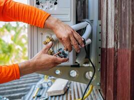 Air conditioning technicians install new compressor air in homes, Repairman fix air conditioning systems, Male technician service for repair and maintenance of air conditioners photo