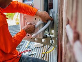Air conditioning technicians install new compressor air in homes, Repairman fix air conditioning systems, Male technician service for repair and maintenance of air conditioners photo