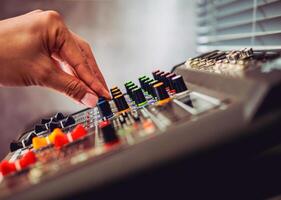 Close-up of sound engineer hands adjusting control sound mixer in recording, broadcasting studio,Sound mixer. Professional audio mixing console, buttons, faders and sliders. sound check. photo