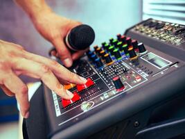 Close-up of sound engineer hands adjusting control sound mixer in recording, broadcasting studio,Sound mixer. Professional audio mixing console, buttons, faders and sliders. sound check. photo