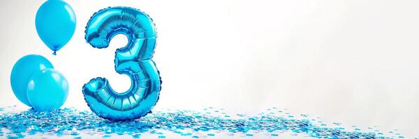 A festive celebration of the third birthday with balloons and confetti in blue pastel tones, an inflatable balloon with the number 3 on a white background. Banner with copy space. photo