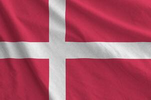 Denmark flag depicted on folded wavy fabric of old cloth photo
