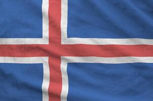 Iceland flag depicted on folded wavy fabric of old cloth photo