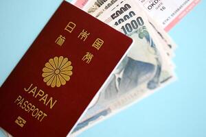 Japan passport with money and airline tickets on blue background close up photo