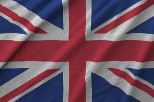 Great britain flag depicted on folded wavy fabric of old cloth photo