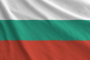 Bulgaria flag depicted on folded wavy fabric of old cloth photo