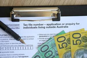 KYIV, UKRAINE - JULY 10, 2024 Australian Tax File Number Application or enquiry for individuals living outside Australia blank form lies on table of Australian Government taxation office photo