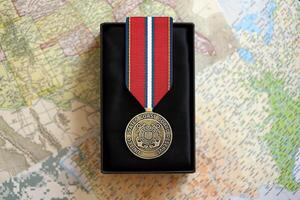 KYIV, UKRAINE - JULY 10, 2024 US Coast Guard Reserve Good Conduct medal. United States military award medal with ribbon and pin. Handmade paper theater props photo