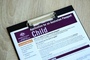 KYIV, UKRAINE - JULY 10, 2024 Application for an Australian passport for child blank forms on table. Department of foreign affairs and Trade photo