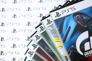 KYIV, UKRAINE - JUNE 26, 2024 Stack of games for Sony Playstation 5 and 4 console. Many disc boxes of popular games photo