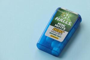 KYIV, UKRAINE - APRIL 20, 2024 Halls mini mints mint twist energy vitamin b6 small blue case with hard mints inside on blue background photo