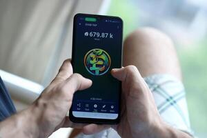 KYIV, UKRAINE - APRIL 20, 2024 EVAB TAP telegram bot on smartphone screen. EVAB TAP is a viral Telegram based crypto game for earn tokens by managing virtual crypto exchange photo