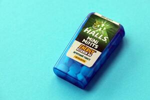 KYIV, UKRAINE - APRIL 20, 2024 Halls mini mints mint twist energy vitamin b6 small blue case with hard mints inside on blue background photo