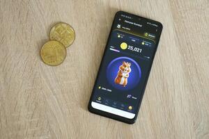 KYIV, UKRAINE - APRIL 20, 2024 Hamster Kombat telegram bot on smartphone screen. Hamster Kombat is a viral Telegram crypto game for earn HMSTR tokens by managing virtual crypto exchange photo