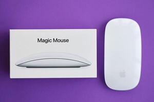 KYIV, UKRAINE - NOVEMBER 27, 2023 Apple Magic Mouse 3rd generation lies on bright colored background photo