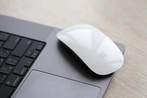 KYIV, UKRAINE - NOVEMBER 27, 2023 Apple Magic Mouse 3rd generation lies with grey MacBook 2021 photo