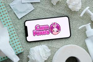 KYIV, UKRAINE - JANUARY 23, 2024 CamFoxes adult content website logo on display of iPhone 12 Pro photo