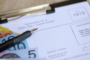 KYIV, UKRAINE - JULY 10, 2024 Australian application for a visitor visa Form 1419 to travel to Australia on table photo
