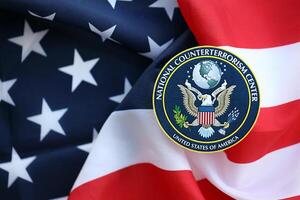 KYIV, UKRAINE - JUNE 26, 2024 United States National Counterterrorism Center coat of arms sticker on folded US flag photo