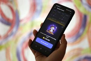 KYIV, UKRAINE - JUNE 26, 2024 Hamster Kombat telegram mini-game in tap 2 earn genre. Tap game on smartphone in hand photo