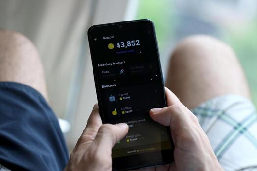 KYIV, UKRAINE - APRIL 20, 2024 Notcoin telegram bot on smartphone screen. Notcoin is a viral Telegram based crypto game for earn tokens by managing virtual crypto exchange photo