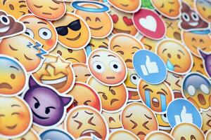 KYIV, UKRAINE - APRIL 20, 2024 Large set of stickers with Emoji yellow faces. Emoji is a pictogram or smiley embedded in text and used in electronic messages photo