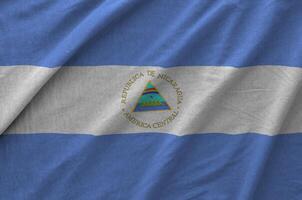 Nicaragua flag depicted on folded wavy fabric of old cloth photo