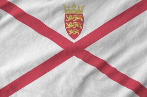 Jersey flag depicted on folded wavy fabric of old cloth photo