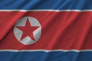 North Korea flag depicted on folded wavy fabric of old cloth photo