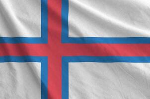 Faroe islands flag depicted on folded wavy fabric of old cloth photo