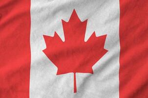 Canada flag depicted on folded wavy fabric of old cloth photo