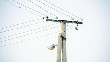 Electric utility pole with overhead power lines and a streetlamp, representing infrastructure and energy supply challenges photo