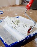 A close up of a paint roller covered in white paint during a home renovation project, symbolizing transformation and improvement photo