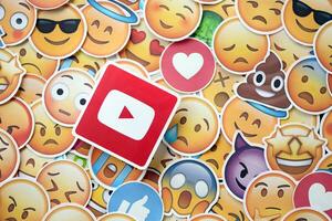KYIV, UKRAINE - APRIL 20, 2024 YouTube logo and large set of stickers with Emoji yellow faces. Emoji is a pictogram or smiley embedded in text and used in electronic messages photo