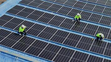 Worker Technicians are working to construct solar panels system on roof. Installing solar photovoltaic panel system. Men technicians carrying photovoltaic solar modules on roof. video